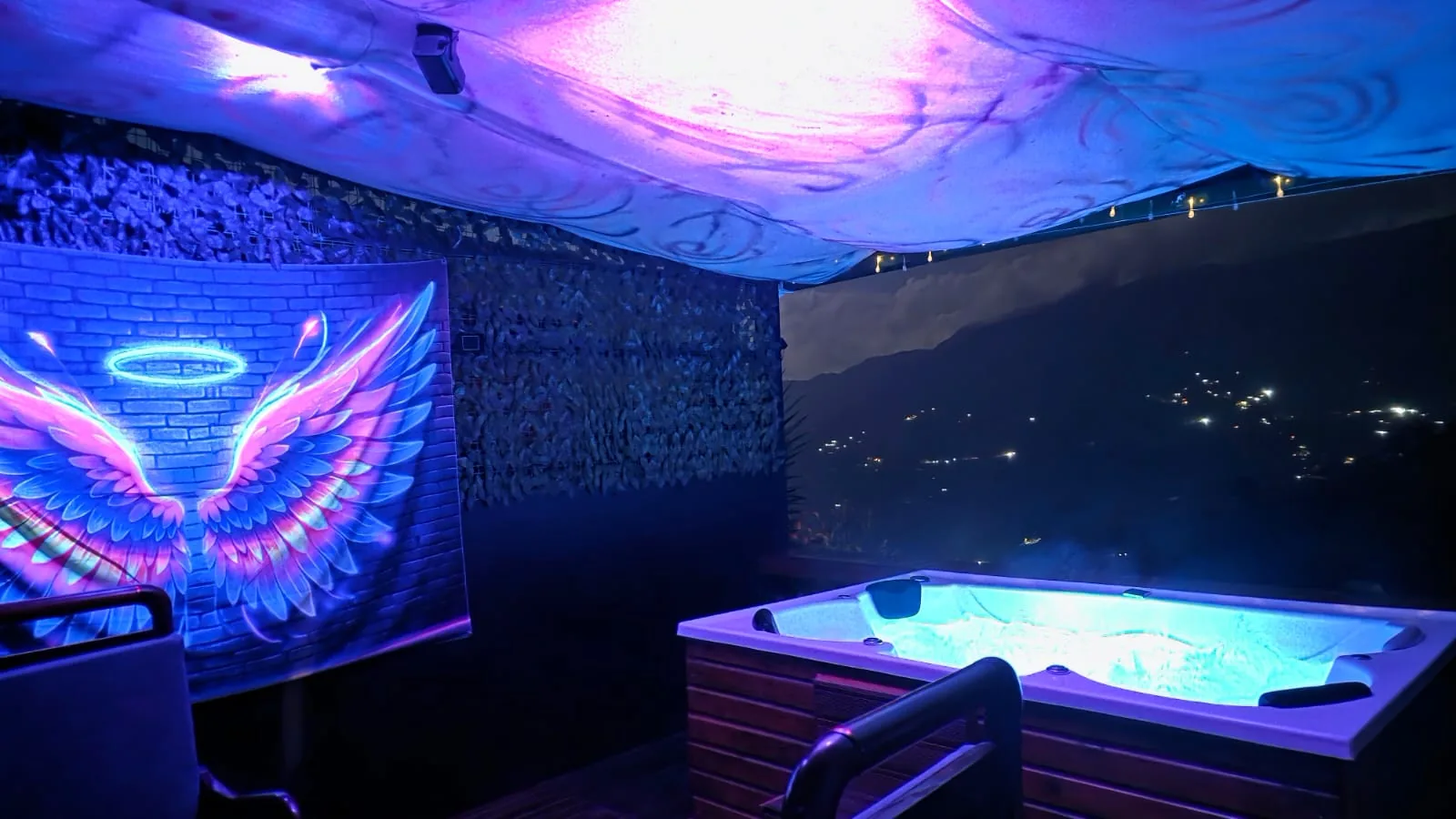 Jacuzzi privado iluminado con vista nocturna en Gualanday Glamping